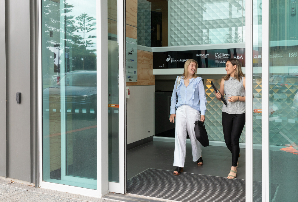 The Property Group - Emma May - Walking out of the office with laptop bag and gym bag