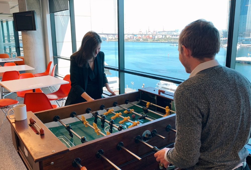 Marta playing table football with colleague during lunch break