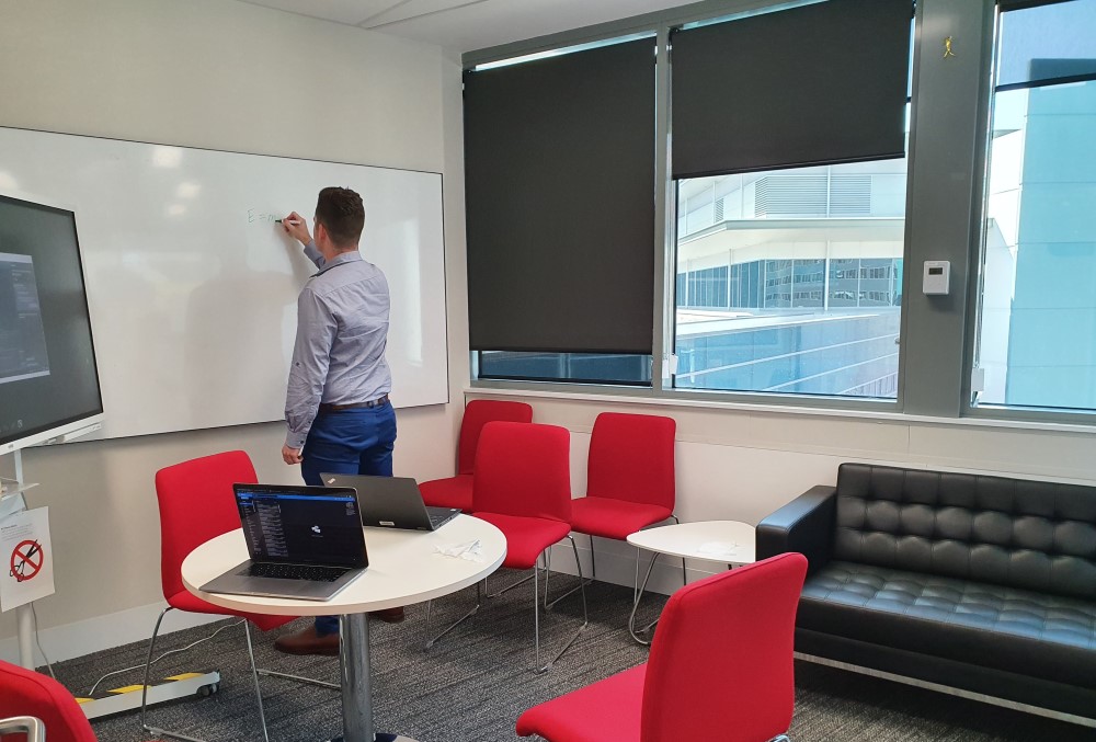 Capgemini Australia Graduate - Male professional writing on a white board.