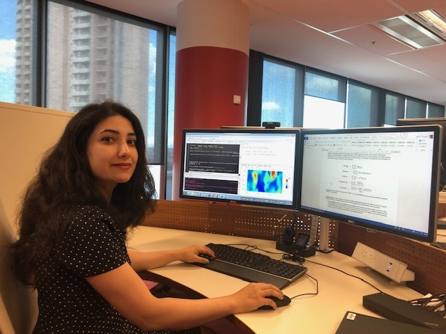Tahereh in front of her computer workspace