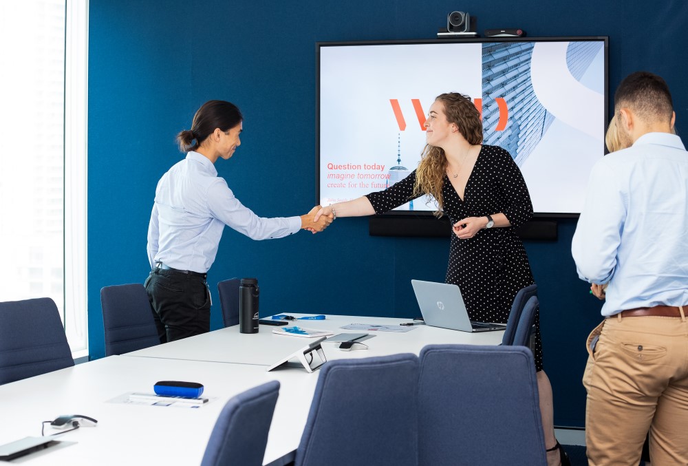 WSP Graduate- A young female professional handshaking a client.