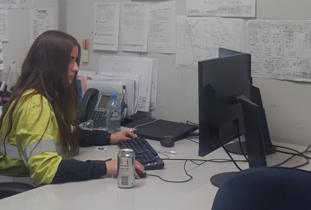Alcoa of Australia Graduate - Young female professional sitting on her desk.