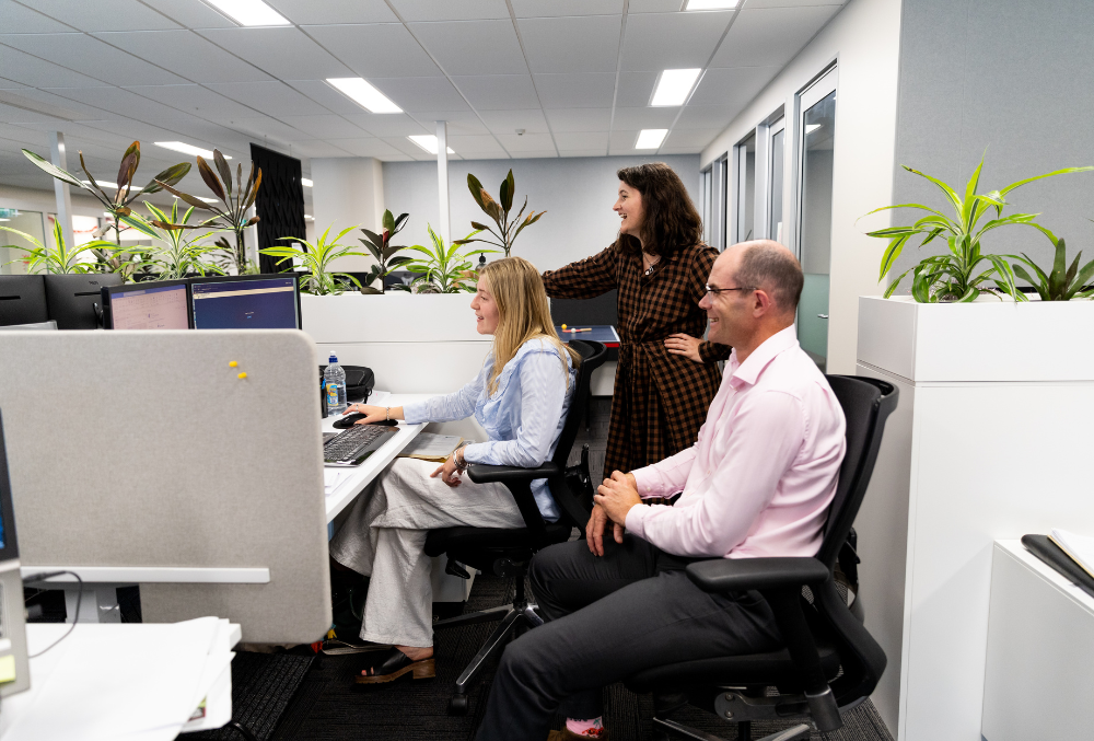 The Property Group - Emma May - Gareth and Emma talking and pointing at a piece of paper in their pod