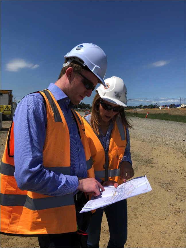 Two young professionals having a meeting on site